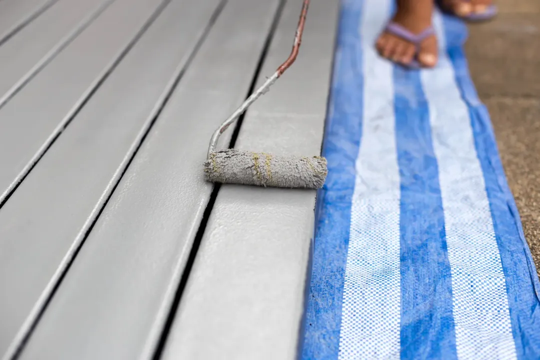 A man painting a composite decking
