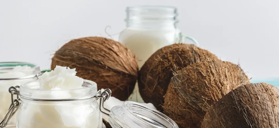 coconuts and jars of coconut butter - Does Coconut Oil Help With Eczema? - Palm Beach Dermatology Group